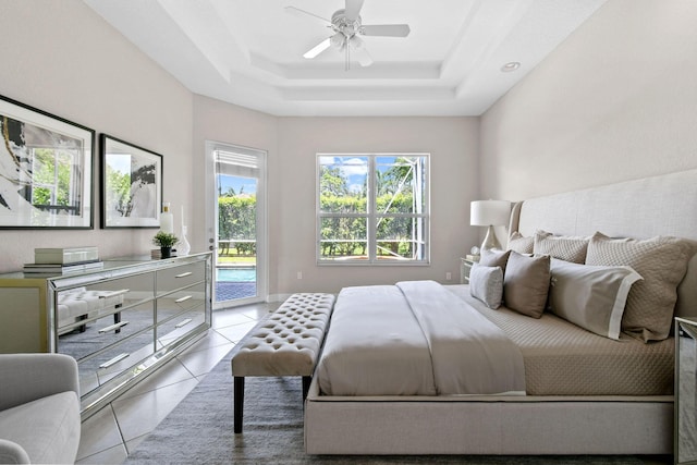 bedroom with light tile patterned flooring, access to outside, ceiling fan, and a tray ceiling