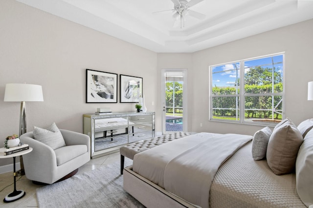 tiled bedroom with a raised ceiling, access to outside, and ceiling fan