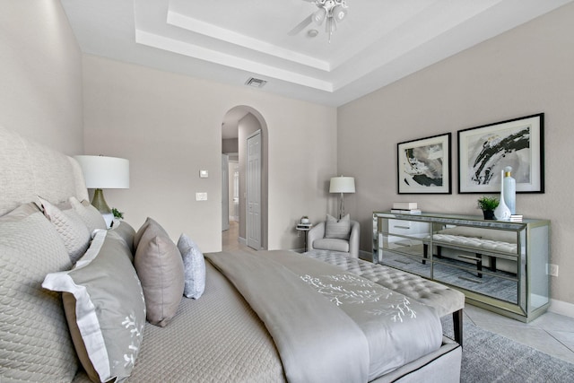 bedroom featuring light tile patterned floors and a tray ceiling