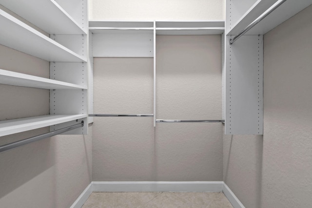 walk in closet with light tile patterned floors