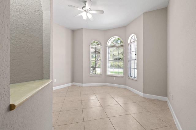 unfurnished room with light tile patterned floors and ceiling fan