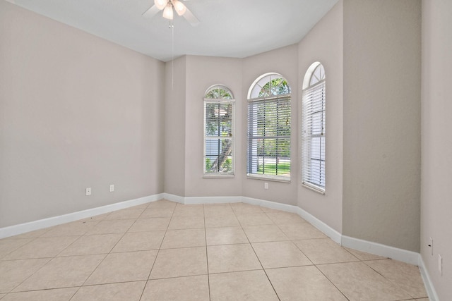 empty room with ceiling fan and light tile patterned flooring