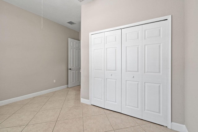 unfurnished bedroom with light tile patterned flooring and a closet