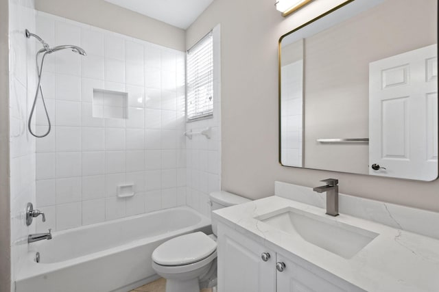 full bathroom featuring vanity, tiled shower / bath combo, and toilet