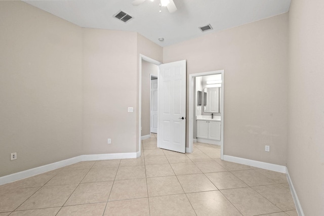 unfurnished bedroom featuring ensuite bath, ceiling fan, and light tile patterned flooring