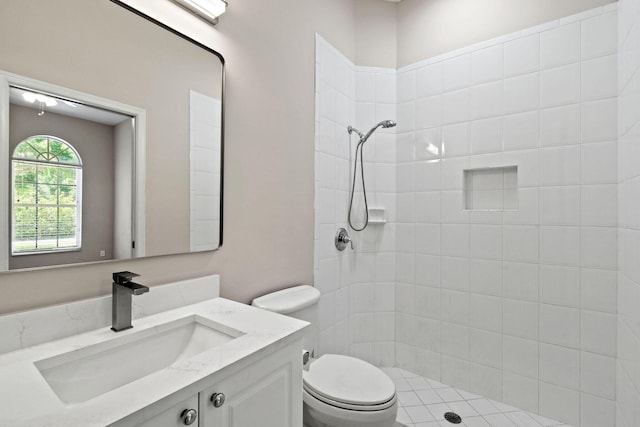 bathroom with vanity, toilet, and a tile shower