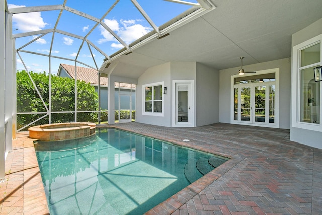 view of swimming pool featuring french doors, a patio area, glass enclosure, an in ground hot tub, and ceiling fan