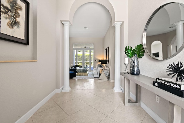 hallway with french doors, decorative columns, and light tile patterned floors