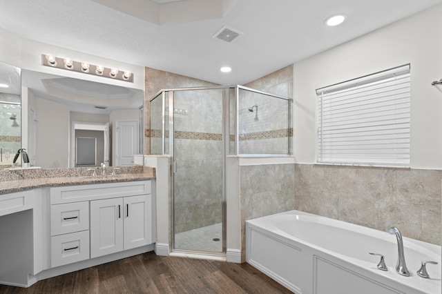 bathroom featuring independent shower and bath, hardwood / wood-style flooring, and vanity