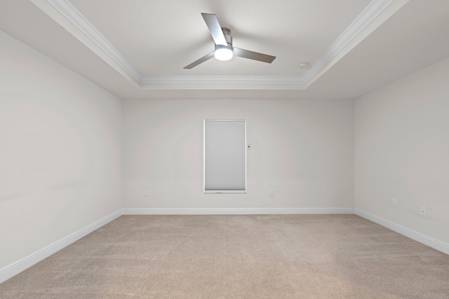 unfurnished room with a tray ceiling, carpet flooring, ceiling fan, and crown molding