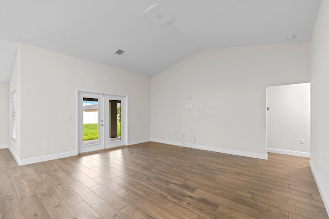 spare room with hardwood / wood-style floors, french doors, and lofted ceiling