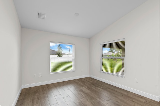 unfurnished room with lofted ceiling and dark hardwood / wood-style flooring