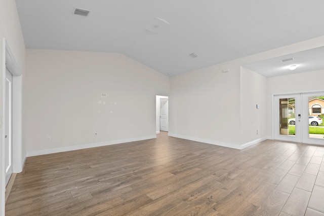 empty room featuring vaulted ceiling and wood-type flooring