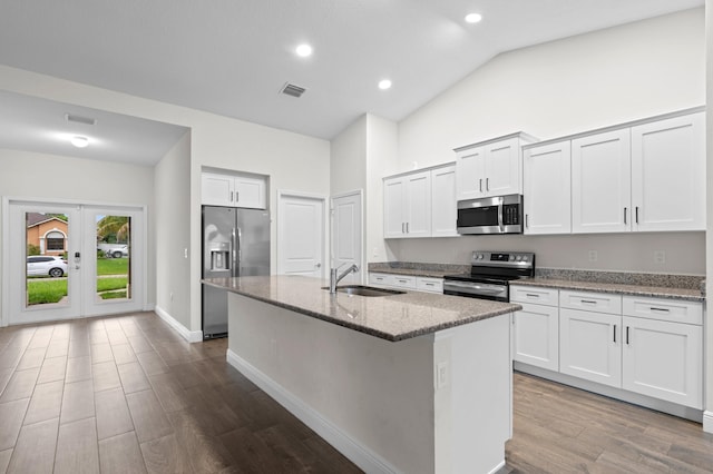 kitchen featuring stainless steel appliances, sink, light stone countertops, lofted ceiling, and hardwood / wood-style flooring