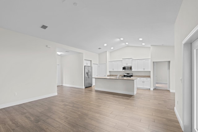 kitchen featuring light wood-type flooring, high vaulted ceiling, a kitchen island with sink, white cabinets, and stainless steel appliances