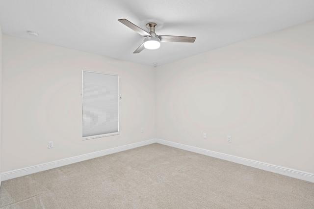 empty room featuring ceiling fan and light carpet