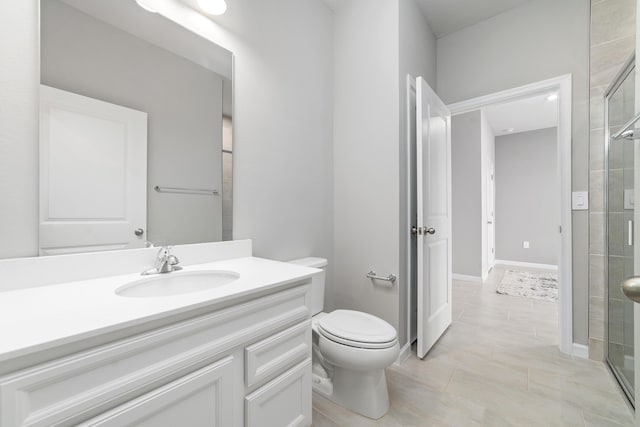 bathroom with tile patterned flooring, vanity, a shower with shower door, and toilet