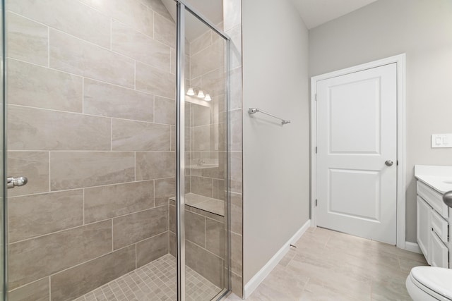 bathroom with tile patterned floors, vanity, toilet, and a shower with shower door