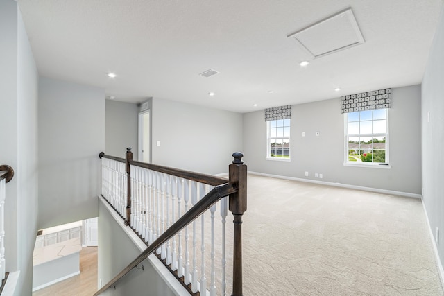 hallway featuring light colored carpet