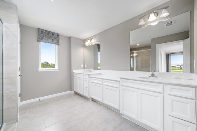 bathroom featuring tile patterned flooring, vanity, a healthy amount of sunlight, and a shower with shower door