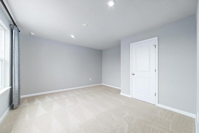 unfurnished room featuring light carpet