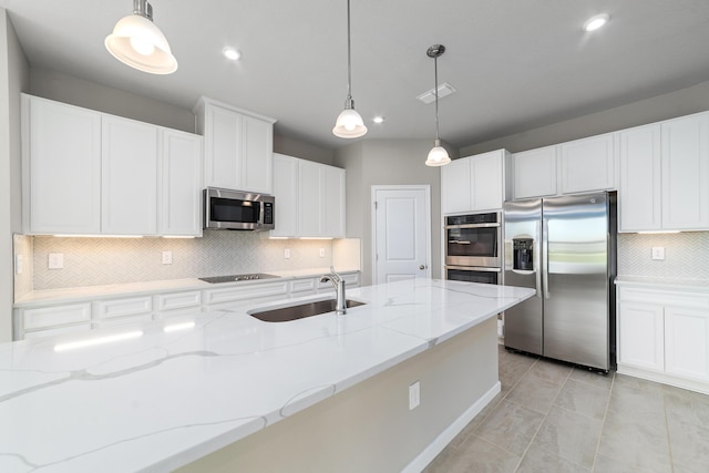 kitchen featuring white cabinetry, light stone counters, decorative light fixtures, and appliances with stainless steel finishes