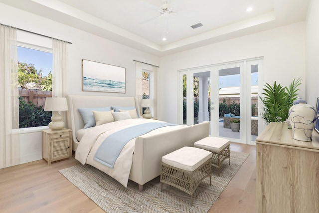 bedroom featuring ceiling fan, access to exterior, light hardwood / wood-style flooring, and multiple windows