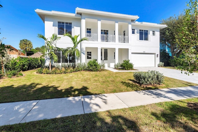 view of front facade with a garage, a balcony, and a front lawn