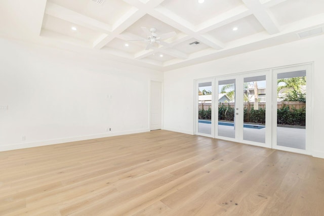 empty room with coffered ceiling, beam ceiling, french doors, and light hardwood / wood-style flooring