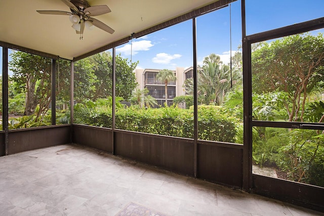 unfurnished sunroom featuring ceiling fan