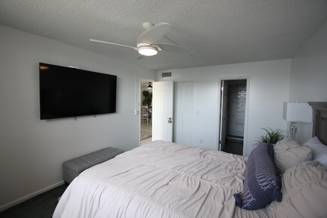 bedroom with ensuite bath, carpet, ceiling fan, and a textured ceiling