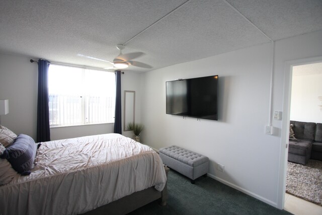 carpeted bedroom with a textured ceiling and ceiling fan