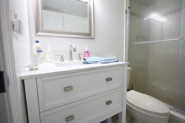 bathroom with walk in shower, toilet, and vanity