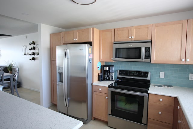 kitchen featuring light tile patterned flooring, tasteful backsplash, light brown cabinets, and stainless steel appliances