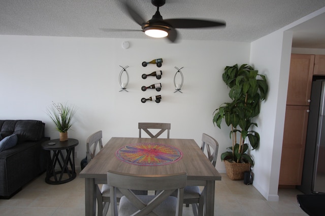 dining room featuring a textured ceiling, ceiling fan, and light tile patterned floors