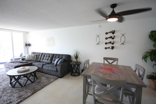 living room featuring a textured ceiling, ceiling fan, and light tile patterned floors