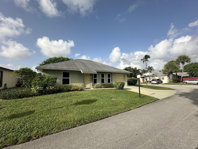 4634 Pine Grove Dr, Delray Beach, FL 33445 - ranch-style house featuring an attached garage, stucco siding, a front lawn, and concrete driveway
