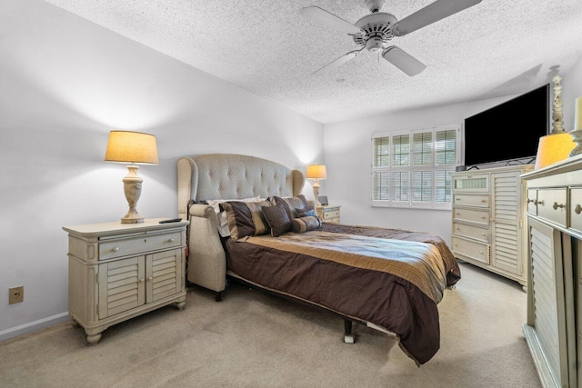 carpeted bedroom with ceiling fan and a textured ceiling