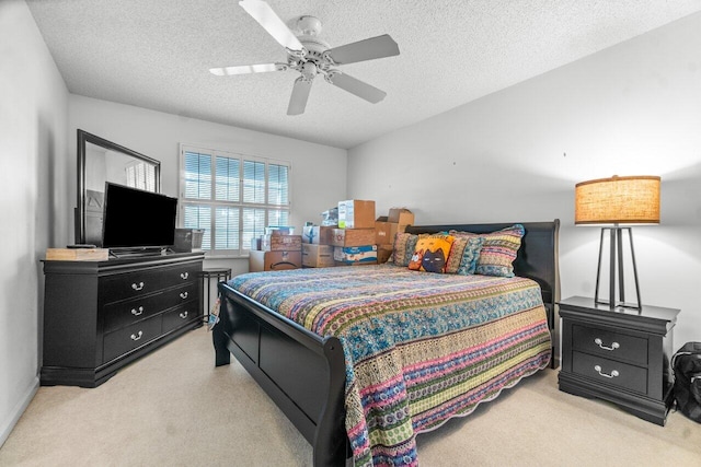 bedroom featuring ceiling fan, a textured ceiling, and light carpet