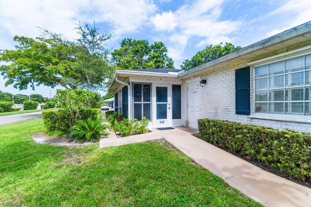 view of exterior entry with a yard