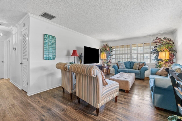 living room featuring ornamental molding, a textured ceiling, and dark wood-type flooring