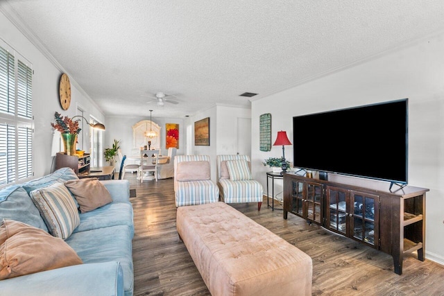 living room featuring ceiling fan with notable chandelier, a textured ceiling, dark hardwood / wood-style floors, and crown molding