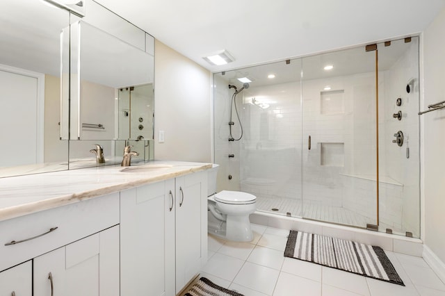 bathroom with tile patterned flooring, vanity, a shower with door, and toilet