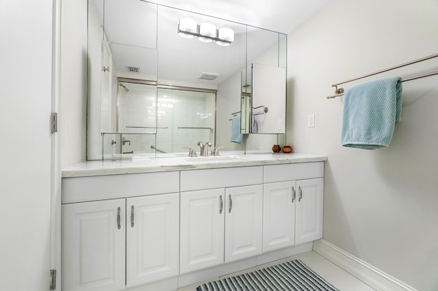 bathroom featuring tile patterned floors, vanity, and a shower with door