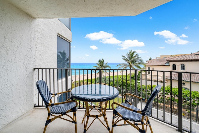 balcony featuring a beach view and a water view