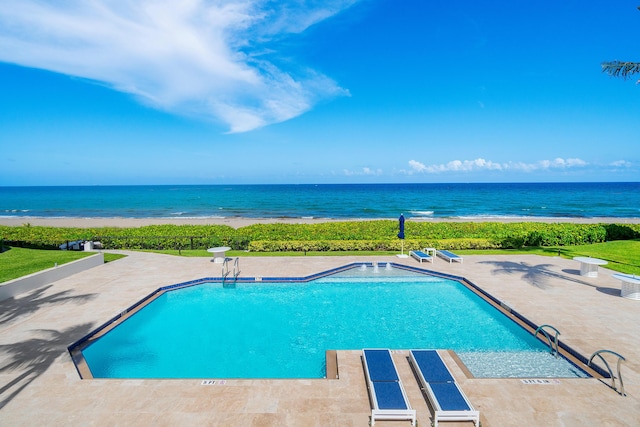 view of swimming pool featuring a patio and a water view