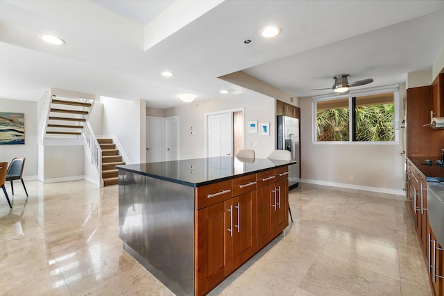 kitchen with stainless steel fridge with ice dispenser, a kitchen island, and ceiling fan