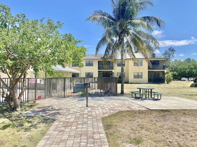 surrounding community with a lawn and a patio area