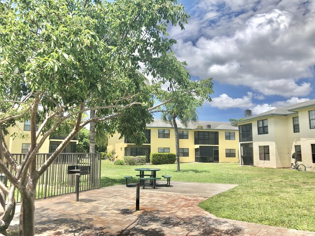 view of property's community featuring a patio area and a lawn