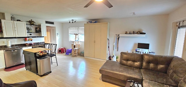 kitchen featuring light hardwood / wood-style floors, a kitchen island, dishwasher, and a wealth of natural light